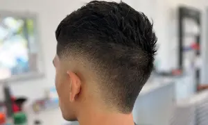 Corte de pelo moderno con un degradado **burst fade** que se desvanece suavemente desde la nuca hacia las orejas.