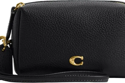 Bolso negro de piel texturizada de Coach con detalle de "C" dorada y correa de mano.