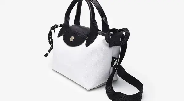 Bolso Longchamp blanco y negro, con asas de cuero y correa ajustable. Ideal para un look moderno y chic.