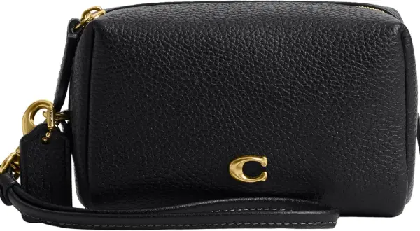 Bolso negro de piel texturizada de Coach con detalle de "C" dorada y correa de mano.