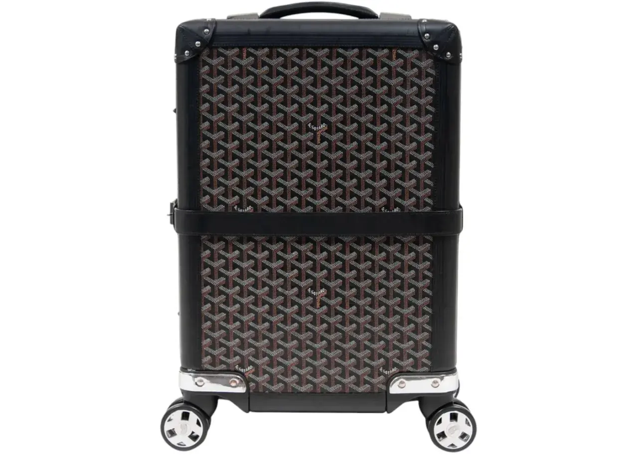 Maleta Goyard con estampado clásico en negro y marrón, detalles en cuero y ruedas plateadas.