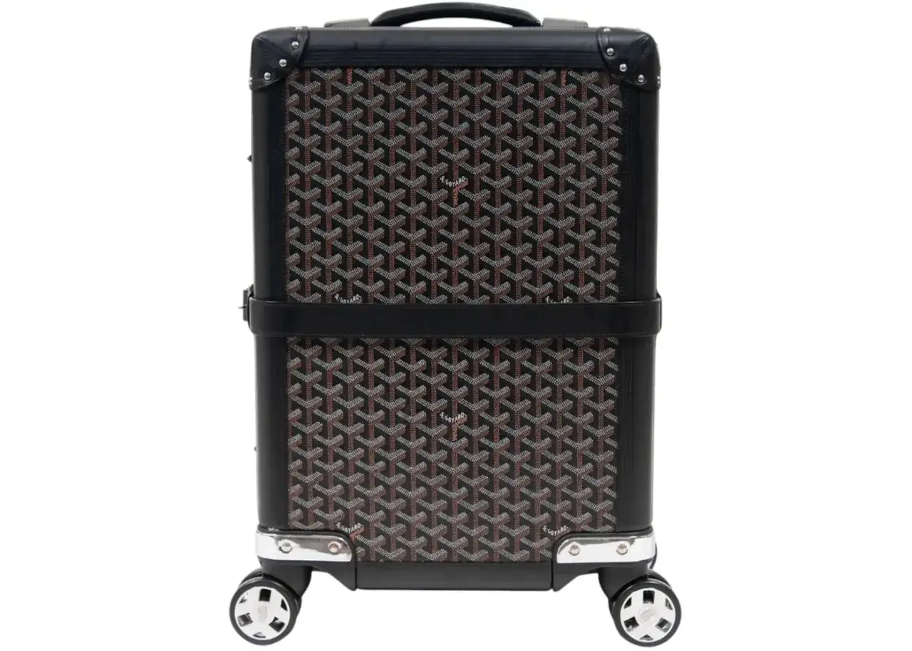 Maleta Goyard con estampado clásico en negro y marrón, detalles en cuero y ruedas plateadas.