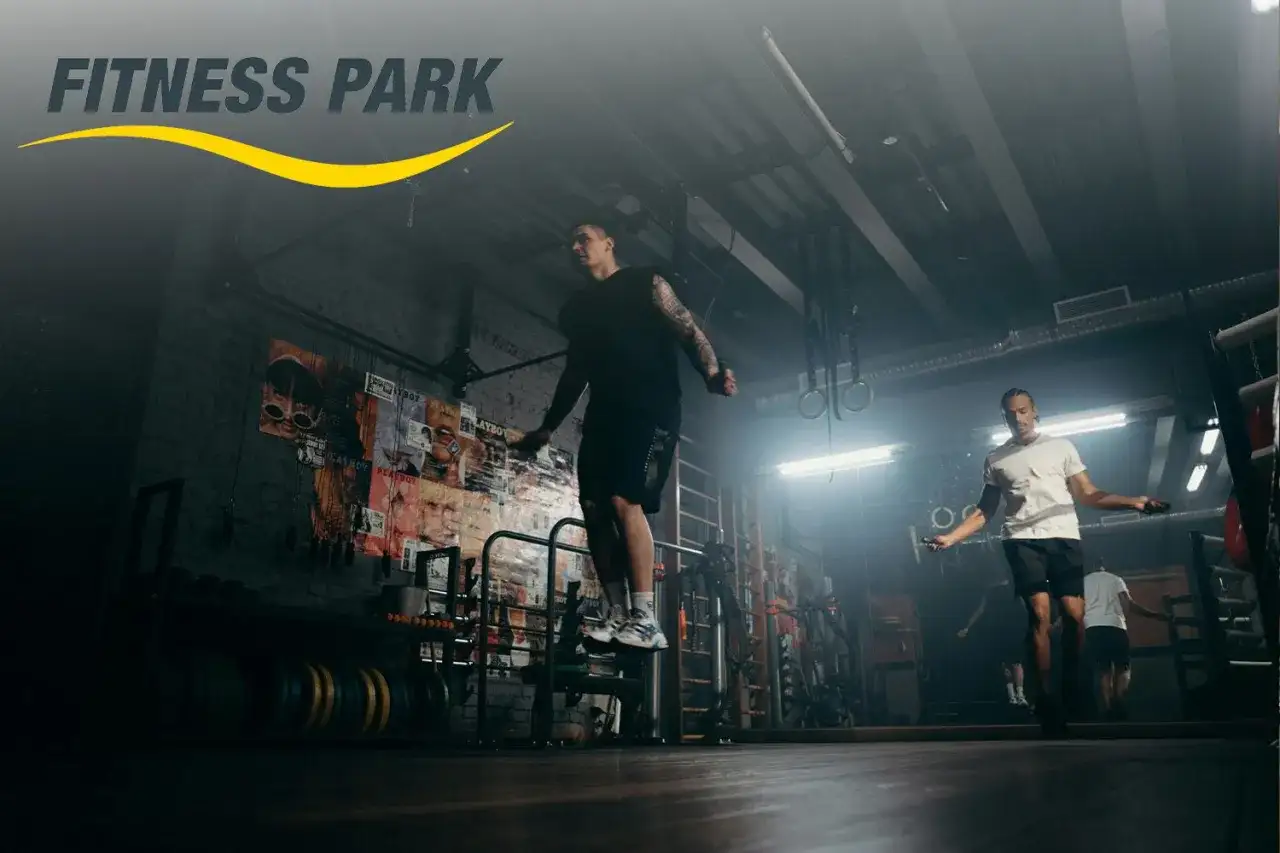 Hombres entrenando en un fitness park, saltando la cuerda en un gimnasio con estilo industrial.